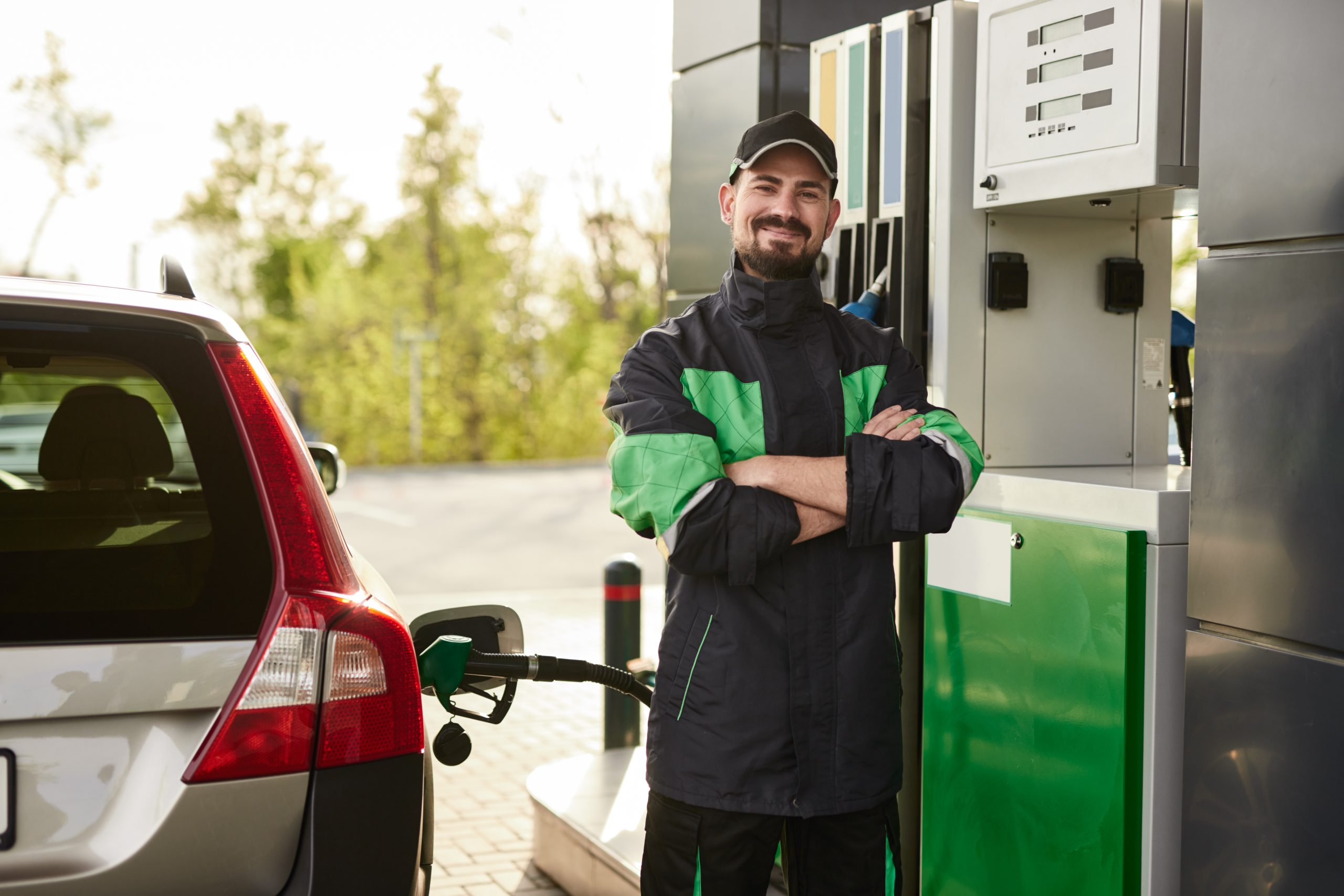 Positive gas station worker near car Positive gas station worker near car